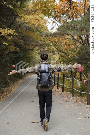 Asian handsome man trekking, climbing autumn mountain Asian handsome man trekking, climbing autumn mountain 76394138