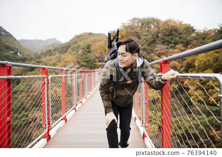Asian handsome man with mask trekking, climbing autumn mountain Asian handsome man with mask trekking, climbing autumn mountain 76394140