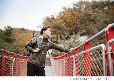 Asian handsome man with mask trekking, climbing autumn mountain Asian handsome man with mask trekking, climbing autumn mountain 76394148