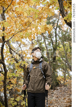 Asian handsome man with mask trekking, climbing autumn mountain Asian handsome man with mask trekking, climbing autumn mountain 76394155