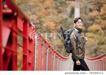 Asian handsome man with mask trekking, climbing autumn mountain Asian handsome man with mask trekking, climbing autumn mountain 76394211