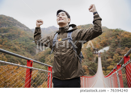 Asian handsome man with mask trekking, climbing autumn mountain Asian handsome man with mask trekking, climbing autumn mountain 76394240