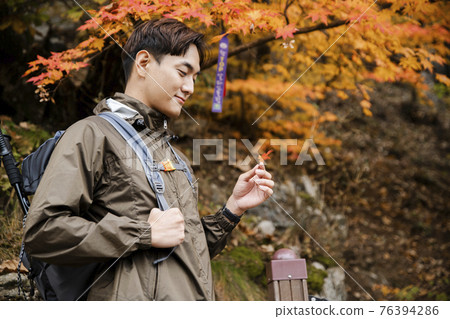 Asian handsome man with mask trekking, climbing autumn mountain Asian handsome man with mask trekking, climbing autumn mountain 76394286