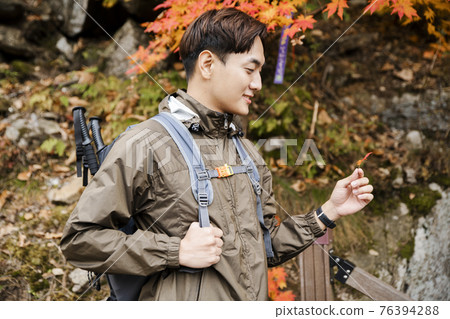 Asian handsome man with mask trekking, climbing autumn mountain Asian handsome man with mask trekking, climbing autumn mountain 76394288