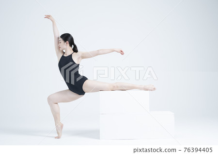contemporary Asian female dancer making move in white background 76394405