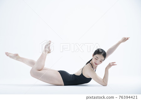 contemporary Asian female dancer making move in white background 76394421