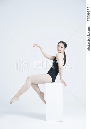 contemporary Asian female dancer making move in white background 76394724