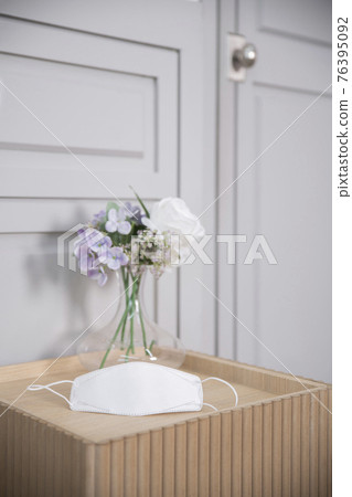 mask on table with flowers mask on table with flowers 76395092