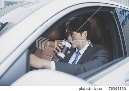 Asian male in suit with coffee in the car, business concept Asian male in suit with coffee in the car, business concept 76395160