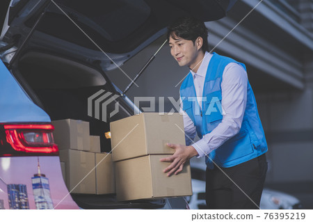 Asian delivery man holding boxes Asian delivery man holding boxes 76395219
