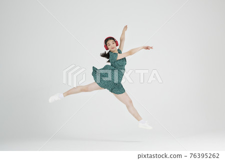 Asian female contemporary dancer making move with headset Asian female contemporary dancer making move with headset 76395262