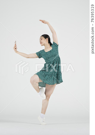 sale promotion concept, contemporary female dancer with smarphone on hand 76395319