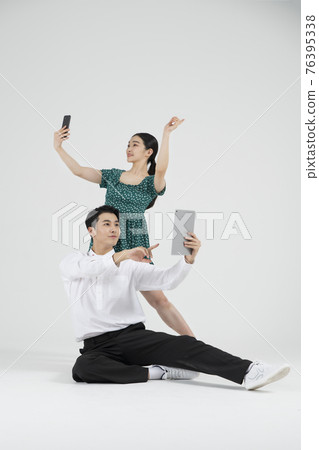 Asian couple contemporary dancers holding tablet and smartphone Asian couple contemporary dancers holding tablet and smartphone 76395338