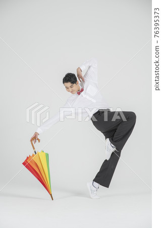 Asian male contemporary dancer making move with unbrella Asian male contemporary dancer making move with unbrella 76395373
