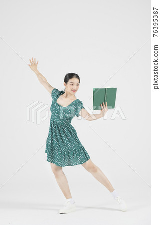 Asian female contemporary dancer holding book Asian female contemporary dancer holding book 76395387