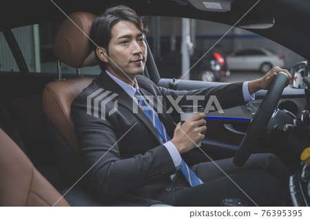 Asian male in suit with coffee in the car, business concept Asian male in suit with coffee in the car, business concept 76395395