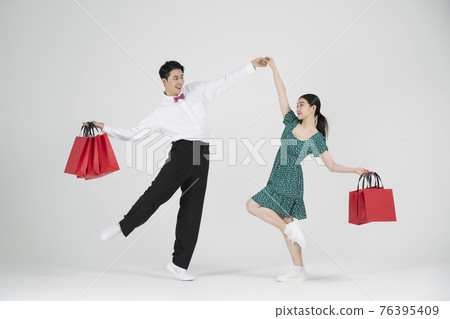 sale promotion concept, contemporary couple dancers with shopping bags sale promotion concept, contemporary couple dancers with shopping bags 76395409