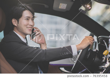 angry Asian male in suit using mobile phone in the car angry Asian male in suit using mobile phone in the car 76395458