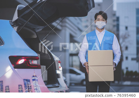 Asian delivery man wearing mask holding boxes Asian delivery man wearing mask holding boxes 76395460
