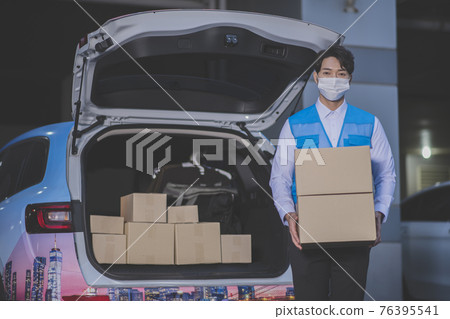 Asian delivery man wearing mask holding boxes Asian delivery man wearing mask holding boxes 76395541