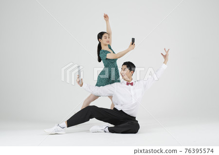 Asian couple contemporary dancers holding tablet and smartphone Asian couple contemporary dancers holding tablet and smartphone 76395574