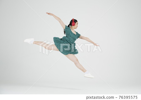 Asian female contemporary dancer making move with headset Asian female contemporary dancer making move with headset 76395575