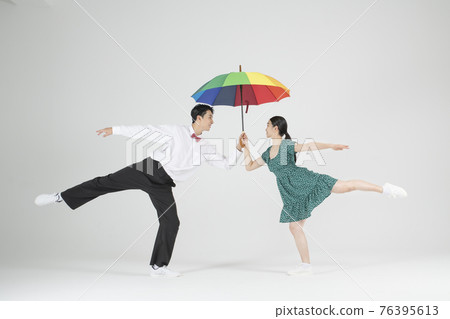 Asian couple contemporary dancers making move with unbrella Asian couple contemporary dancers making move with unbrella 76395613