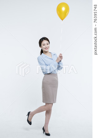 Asian business woman with yellow balloon 76395748