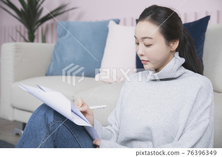 beautiful Asian single solo woman living alone concept writing on papers beautiful Asian single solo woman living alone concept writing on papers 76396349