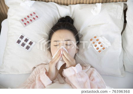 sick Asian woman in bed sick Asian woman in bed 76396368