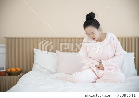 sick Asian woman in bed sick Asian woman in bed 76396511