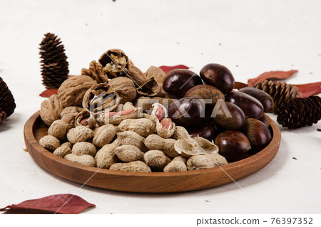 chestnuts, peanuts and walnuts with autumn leaves chestnuts, peanuts and walnuts with autumn leaves 76397352