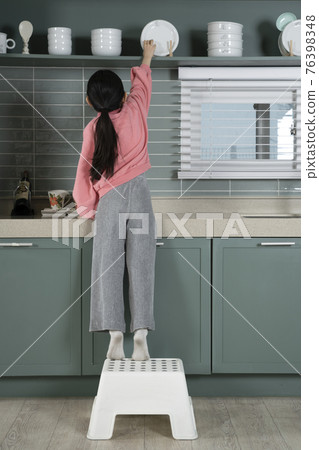 Asian child trying to cook alone in the kitchen Asian child trying to cook alone in the kitchen 76398348