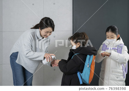 Asian boy and girl with masks cleaning hands with sanitizer Asian boy and girl with masks cleaning hands with sanitizer 76398398