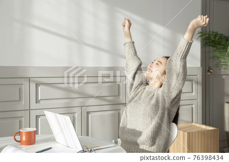 remote work, working at home concept of Asian woman with hair tied back and wearing sweater remote work, working at home concept of Asian woman with hair tied back and wearing sweater 76398434