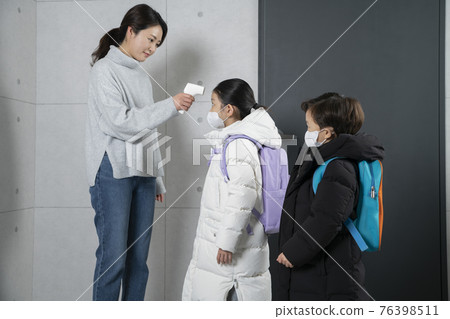 Asian boy and girl with masks measuring temperature Asian boy and girl with masks measuring temperature 76398511