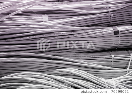 bunch of network cables in wave pattern leading across server ro 76399031