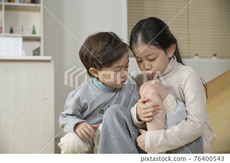 Asian little boy caring wounded sister Asian little boy caring wounded sister 76400543