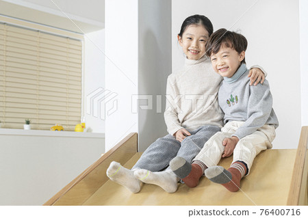 Asian siblings on the slide 76400716