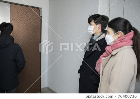 Asian couple with face masks in corridor Asian couple with face masks in corridor 76400730