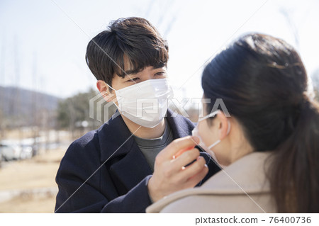 Asian couple with face masks 76400736