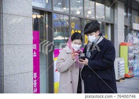 Asian male and female with mask infront of real estate brokerage office Asian male and female with mask infront of real estate brokerage office 76400746