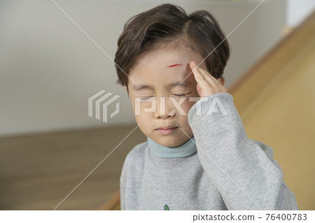 Asian boy with a wound on the forehead due to slide 76400783