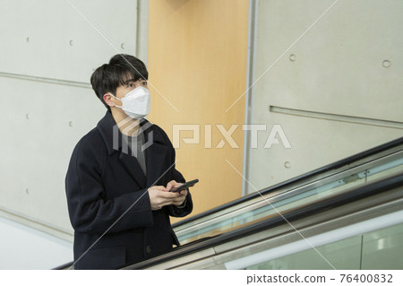 Asian man on escalator with face masks Asian man on escalator with face masks 76400832