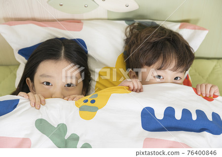 Asian young brother and sister lying on bed Asian young brother and sister lying on bed 76400846