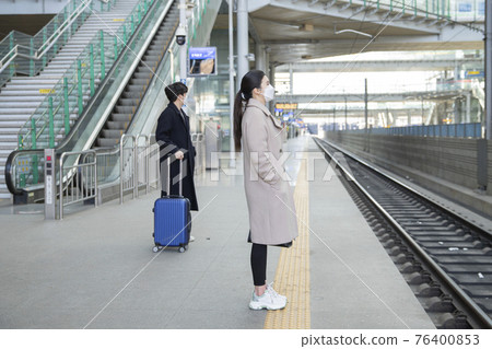 Asian man with masks sanitizing hand in train station Asian man with masks sanitizing hand in train station 76400853