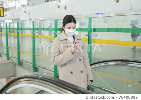 Asian woman on escalator with face masks 76400889
