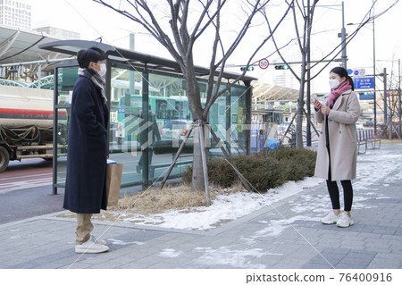 Asian woman and man with face masks handing over paper bag, face to face selling second hand stuffs concept 76400916