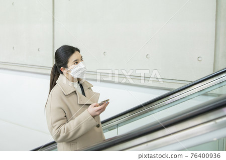 Asian woman on escalator with face masks Asian woman on escalator with face masks 76400936