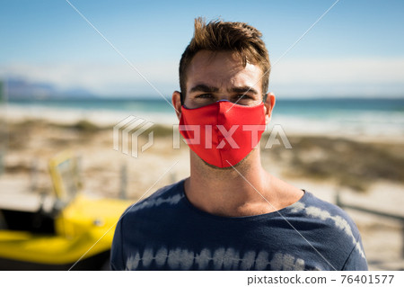 Portrait of happy caucasian man wearing face mask next to beach buggy looking to camera Portrait of happy caucasian man wearing face mask next to beach buggy looking to camera 76401577